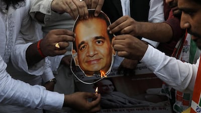 Indian Youth Congress activists burn the mask of billionaire jeweler Nirav Modi and shout slogans against the government during a protest against Bhartiya Janta Party (BJP) led government in Mumbai. EPA/DIVYAKANT SOLANKI