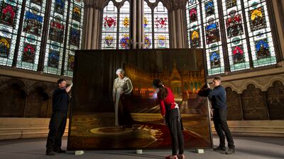 Conservators conduct a condition report on a portrait of the queen before it is placed inside the Chapter House at Westminster Abbey, in 2013. Getty Images