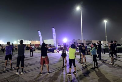 Runners training for the Abu Dhabi marathon warm up at the start of a session on Al Hudayriat Island. Victor Besa / The National