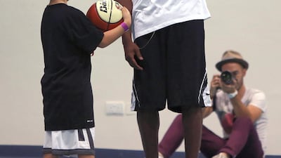 LA Lakers NBA player Kobe Bryant (R) gives advises to a 10-year-old student during a training session at Gems American Academy in Abu Dhabi September, 26, 2013. AFP
