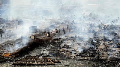 Workers and locals attempt to salvage goods after a fire at Oko-Baba Sawmill, in the Ebute-Metta district of Lagos, Nigeria. Hundreds of people were displaced by the blaze in the city's biggest timber market. AFP