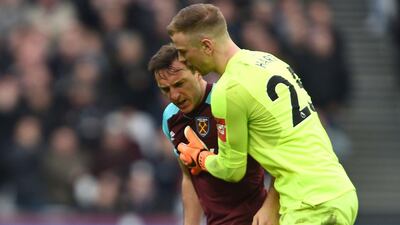A pitch invader falls to the pitch confronted by West Ham's Mark Noble, with goalkeeper Joe Hart, right, during the English Premier League match between Burnley and West Ham at the Olympic London Stadium. Daniel Hambury / PA via AP
