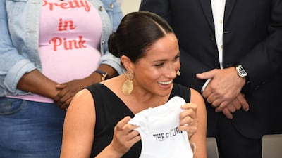 The royal hands out some of Archie's clothes to the group. Getty Images