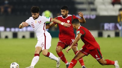 Qatar's Bassam Hisham Al Rawi tries to escape with the ball.