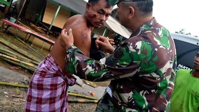 A soldier takes care of a local resident in Pandeglang. Reuters