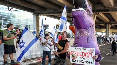 A demonstrator in a dinosaur suit marches at Ben Gurion Airport near Lod. AFP