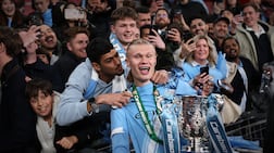 LONDON, ENGLAND - MARCH 22: Erling Haaland of Manchester City holding the Carabao Cup trophy receives a kiss from a fan as he celebrates the team's victory in the Carabao Cup Final match between Arsenal and Manchester City at Wembley Stadium on March 22, 2026 in London, England. (Photo by Julian Finney / Getty Images)