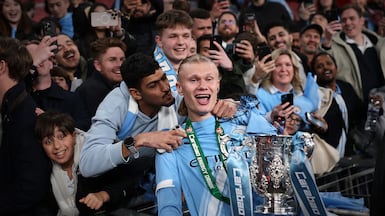 LONDON, ENGLAND - MARCH 22: Erling Haaland of Manchester City holding the Carabao Cup trophy receives a kiss from a fan as he celebrates the team's victory in the Carabao Cup Final match between Arsenal and Manchester City at Wembley Stadium on March 22, 2026 in London, England. (Photo by Julian Finney / Getty Images)