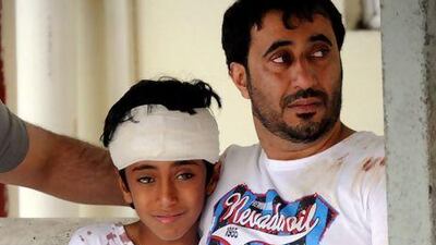 Ali Mohamed Amer, whose pregnant wife and 13-year-old daughter died in the accident, with his eldest son, Mohammed, 11, at Tapah Hospital where the injured were treated. Courtesy FotoBernama