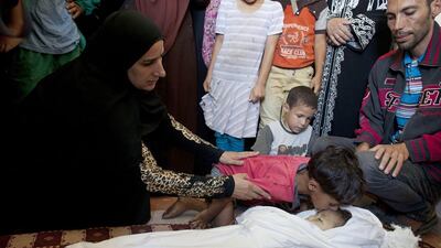 Relatives gather around the tiny body of three-year-old Palestinian girl Jud who was killed by rocket fire near her family home in Beit Lahia, Gaza City on June 24, 2014. It is unclear if an Israeli drone or a Palestinian rocket caused her death. Heidi Levine for The National