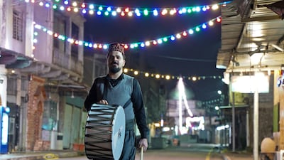 A traditional Iraqi 'musaharati' bangs his drum to wake Muslims for their suhoor meal during Ramadan, near Al Nuri mosque in Mosul's old city. AFP