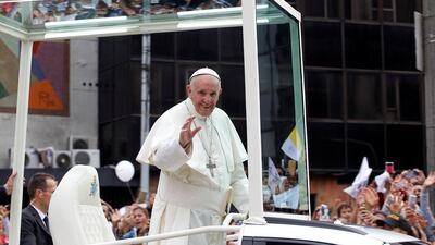 Pope Francis waves to the crowd from the popemobile after visiting an orphanage in Medellin, Colombia in his way to La Macarena stadium