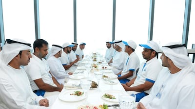 Dr Sultan Al Jaber, Minister of State and chief executive of Adnoc Group, has lunch with the five employees who extinguished a vehicle fire at a petrol station earlier this month. Courtesy Adnoc Group