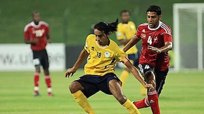 Ahmed Ali of Al Ahli, right, and Mohamed Alsaedi of Al Dhafra tussle for the ball during the first half of their Pro League clash last night. Goals in either half saw Dhafra triumph.