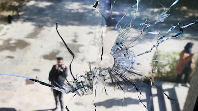 A man taking picture is seen through a broken glass pane inside Kabul's university campus a day after an attack at the Kabul University in Kabul, Afghanistan. EPA