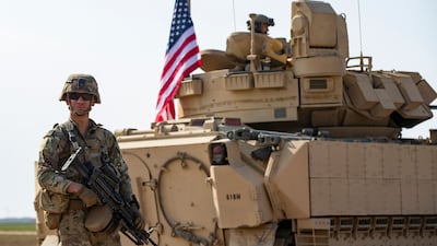 A US soldier stands next to an armoured vehicle near the Syrian town of Tal Hamison last week. AFP