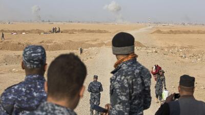 Iraqi federal police officers observe as air and ground strikes hit the town of Shura, some 30 kilometers south of Mosul, Iraq. Marko Drobnjakovic/AP Photo