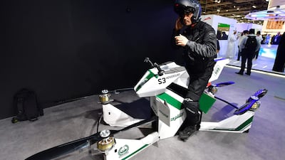 A police officer stands next to a drone motorcycle. AFP