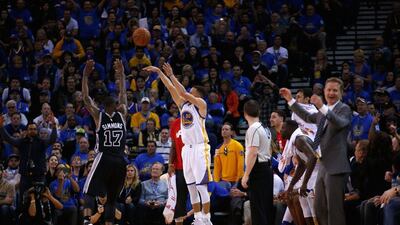 Stephen Curry of the Golden State Warriors shoots a three-point basket over Jonathon Simmons of the San Antonio Spurs on Monday night. Ezra Shaw / Getty Images / AFP