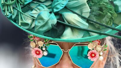 A fan looks on in her funky sunglasses and bright green hat during the Dubai World Cup at Meydan Racecourse. Getty Images