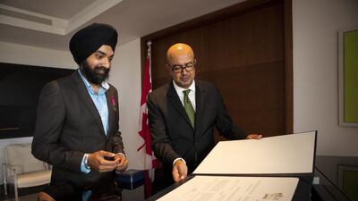 Mandeep Singh, left, receives a decoration for bravery from Arif Lalani, Canadian Ambassador to the UAE, in Abu Dhabi. Christopher Pike / The National