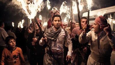 AKRE, IRAQ: Men march with torches during the Newroz festival that marks Kurdish New Year.