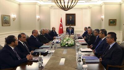 Turkish PM Ahmet Davutoglu, center, his ministers, military commanders and intelligence officials gather during a security meeting in Ankara on July 23, hours before Turkish warplanes struck ISIL targets across the border in Syria. Hakan Goktepe/AP
