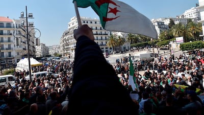 Algerians wave the national flag in Algiers. AFP