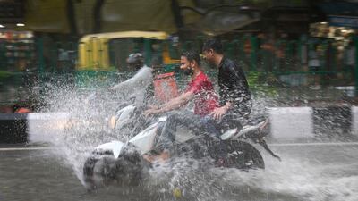 A motorcyclist drives through a waterlogged street during a heavy downpour in Delhi. AP