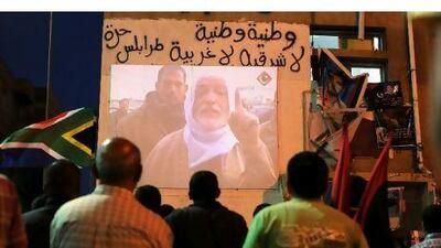 Pro-revolution Libyans watch the opening live broadcast of Libya Alhurra at Revolution Square in Benghazi on Monday. Saeed Khan / AFP Photo