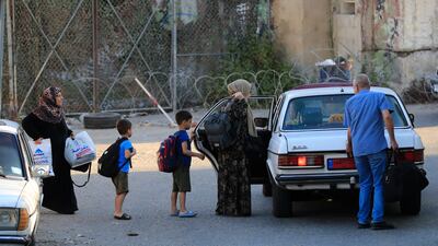 Residents of Ain Al Hilweh, Lebanon's largest camp for Palestinian refugees, flee their homes because of the fighting. AP