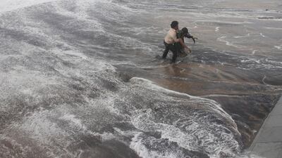 The man carries the woman to safer ground after rescuing her. Reuters