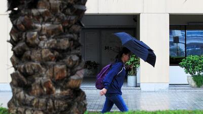 A woman walks in the rain in the Marina area of Dubai. Christopher Pike / The National