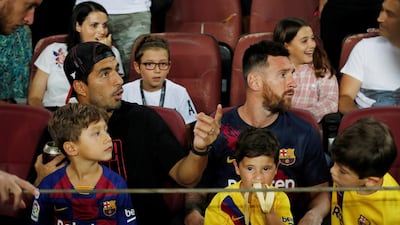 Barcelona's Luis Suarez and Lionel Messi watch the match from the stands. Reuters