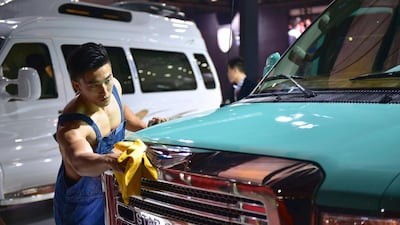 A staff cleans a car of Chinese company Star Coach at the 16th Shanghai International Automobile Industry Exhibition. Johannes Eisele / AFP