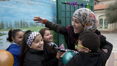 Grade 2 students greet Palestinian teacher Hanan Al Hroub, winner of the Global Teacher Prize, upon her return to Samiha Khalil school in Al Bireh, just outside Ramallah, on March 20, 2016. Ms Al Hroub uses a teaching technique she developed, called “Play and Learn”, which promotes peace and non-violence. Heidi Levine for The National