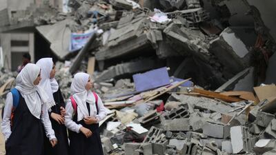 Palestinian pupils look at a building that was destroyed by Israeli air strikes near their school in Gaza City on May 7, 2019. Reuters
