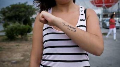 A young woman in Istanbul shows off her tattoo of Mustafa Kemal Ataturk's signature.