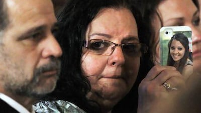 Donna Soto, mother of slain Sandy Hook Elementary School teacher Victoria Soto, holds a cell phone with her daughter's picture on it while attending a ceremony in the East Room of the White House on Friday. Jacquelyn Martin / AP Photo