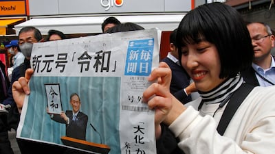 A woman holds a copy of extra edition of Mainichi Shimbun newspaper reporting the name of new era “Reiwa”. AP