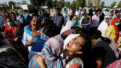 Relatives comfort each other as they mourn the death of Simon Eric, who was killed in a plane crash, during his burial at the Christian's Gora Cemetery in Karachi, Pakistan May 25, 2020. Reuters
