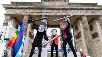 Anti-war activists hold mock nuclear missiles and wear masks of Ayatollah Ali Khamenei, Angela Merkel and Donald Trump in Berlin earlier in the week. EPA