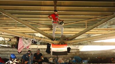 Iraqi demonstrators climb Al Jumhuriya bridge during the ongoing anti-government protests in Baghdad. Reuters
