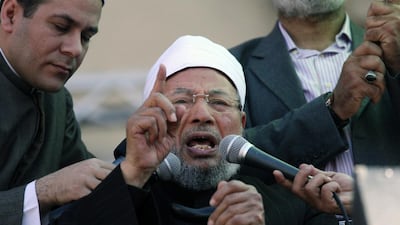 The Doha-based Youssef Al Qaradawi speaks to the crowd as he leads Friday prayers in Tahrir Square in Cairo, Egypt in February, 2011. The outspoken pro-Muslim Brotherhood imam has been critical of the UAE’s policies toward Islamist groups, adding to friction between Qatar and other GCC states. Khalil Hamra / AP Photo