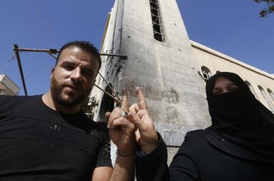 A man and a woman show their ink-stained index fingers after voting for Syria's first local elections since 2011 in eastern Ghouta on the eastern outskirts of the capital Damascus. AFP