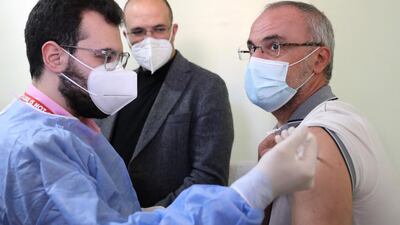 Lebanon's caretaker health minister Hamad Hassan watches as a teacher receives a Covid-19 AstraZeneca vaccine in Beirut. AFP