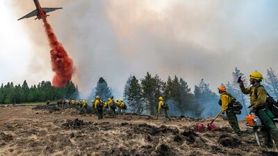 Firefighters watch and record videos with their phones as a plane drops fire retardant on Harlow Ridge above the Lick Creek Fire, south-west of Asotin, Washington. The fire, which started last Wednesday, has now burned over 50,000 acres of land between Asotin County and Garfield County in south-east Washington state.