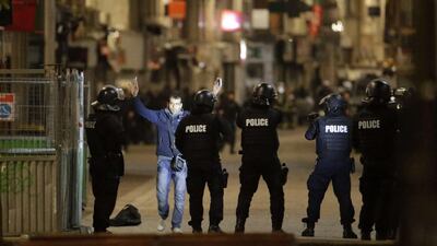 A passerby raises his arms in front of police forces in the northern Paris suburb of Saint-Denis, as police special forces raid an apartment, hunting those behind the attacks that claimed 129 lives in the French capital five days ago. Kenzo Triboouillard / AFP