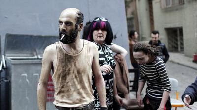 A wounded man with charred hair and skin smokes a cigarette on February 17, 2014, as people try help the injured after an explosion near Taksim Square in Istanbul, Turkey. An explosion occurred in a street, likely due to a gas leak. Sedat Suna / EPA