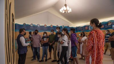 A volunteer explains details of a display to worshippers at the temple.